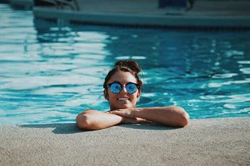 a girl with blue sunglasses in a swimming pool